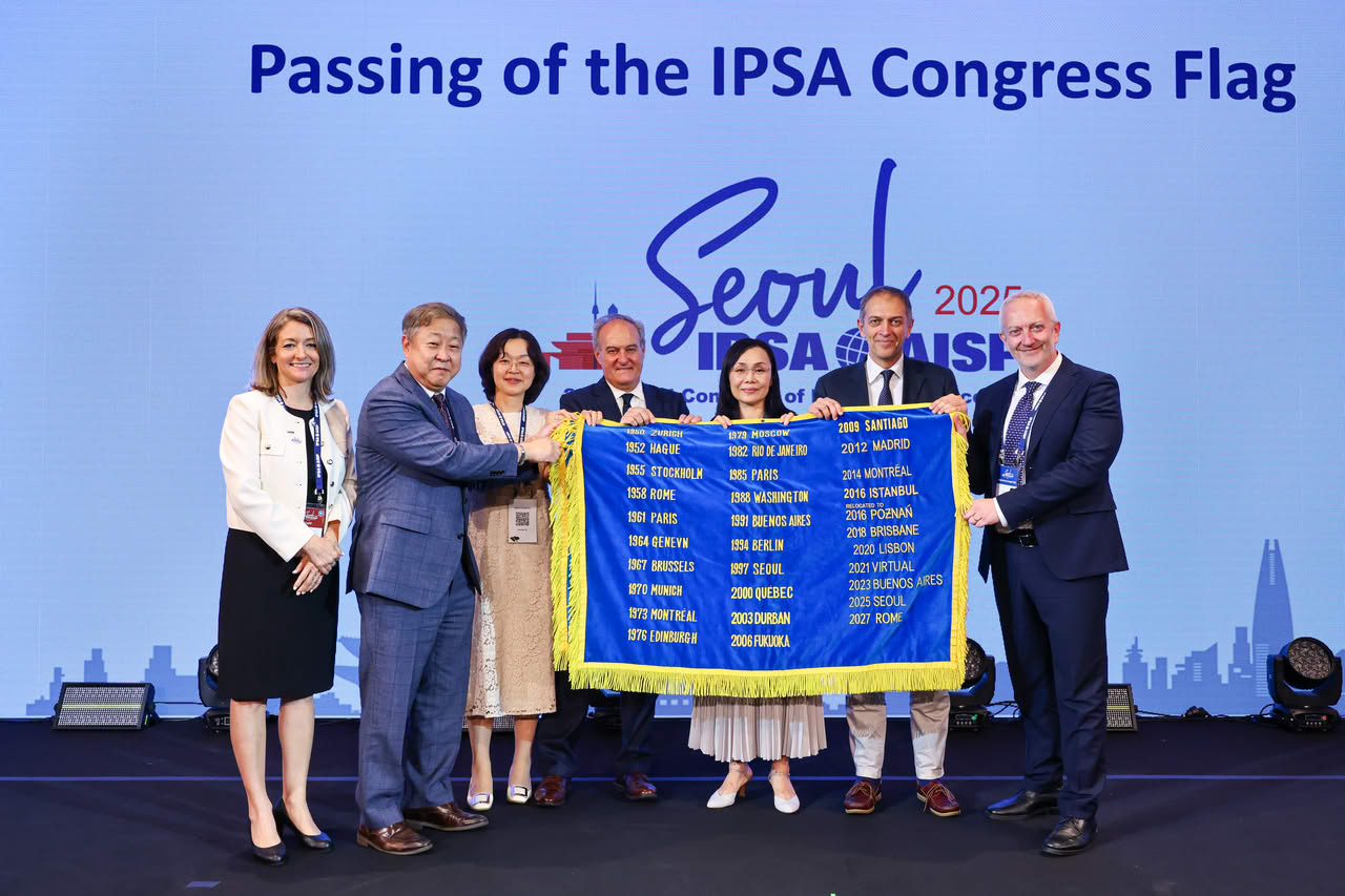 The IPSA Congress flag was officially passed from Seoul (#IPSA2025) to Rome (#IPSA2027) during the Closing Ceremony.
Photo (left to right): Kim Fontaine-Skronski, Euiyoung Kim, Ajin Choi, Pablo Oñate, Yuko Kasuya, Raffaele Marchetti, Fortunato Musella.